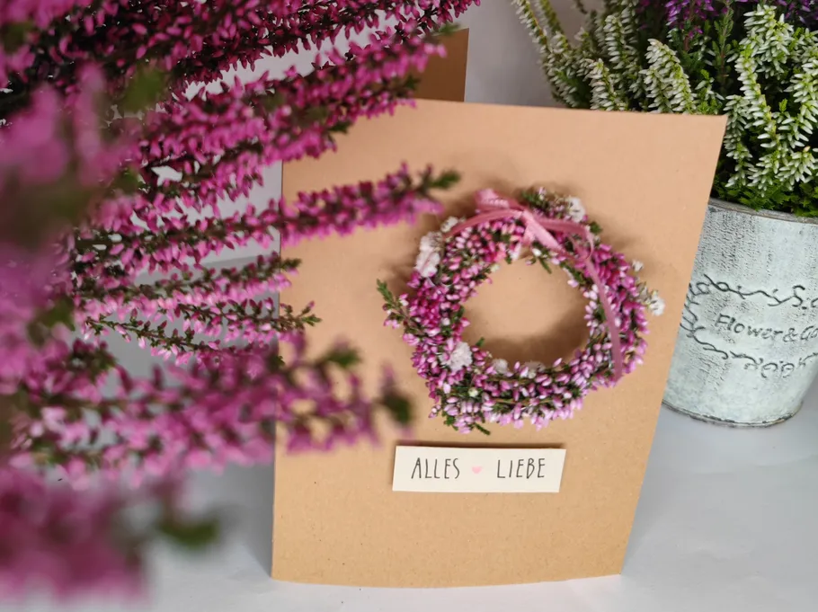 Karte mit pinkem Blumenkranz und Text 'Alles Liebe'.