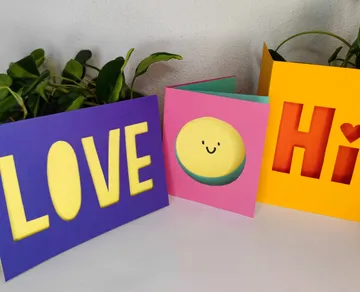 Colorful cards with cutout designs on display.