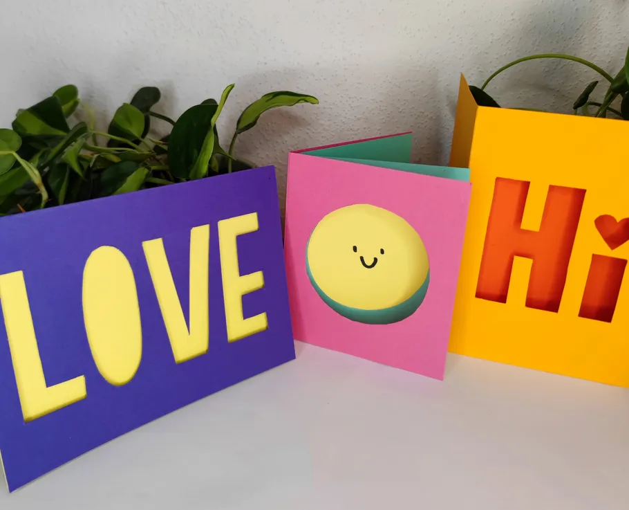 Bunte Karten mit Ausschnittdesigns, wie LOVE oder Smiley.