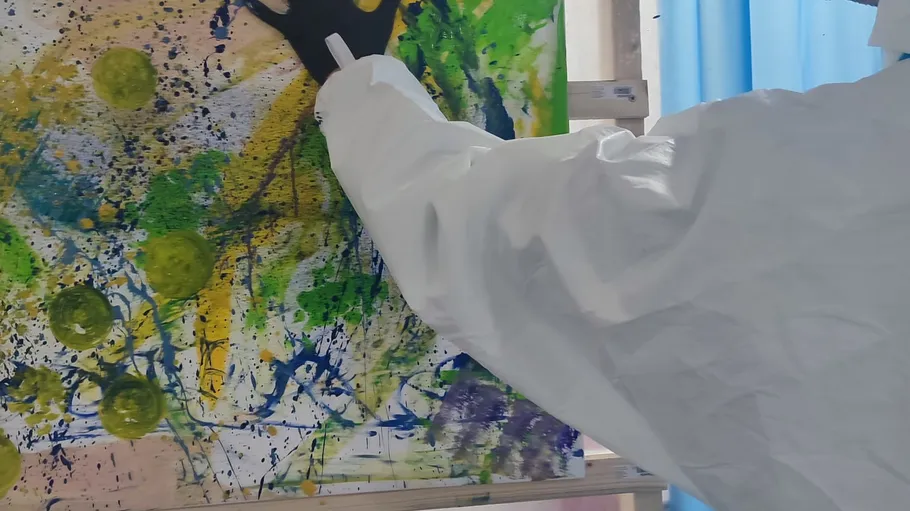 Person painting abstract artwork on canvas.