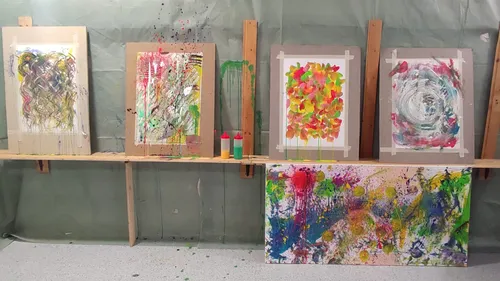 Abstract paintings on a studio wall.