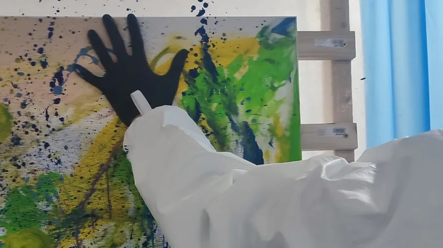 Hand in Handschuh malt bunte abstrakte Leinwand.
