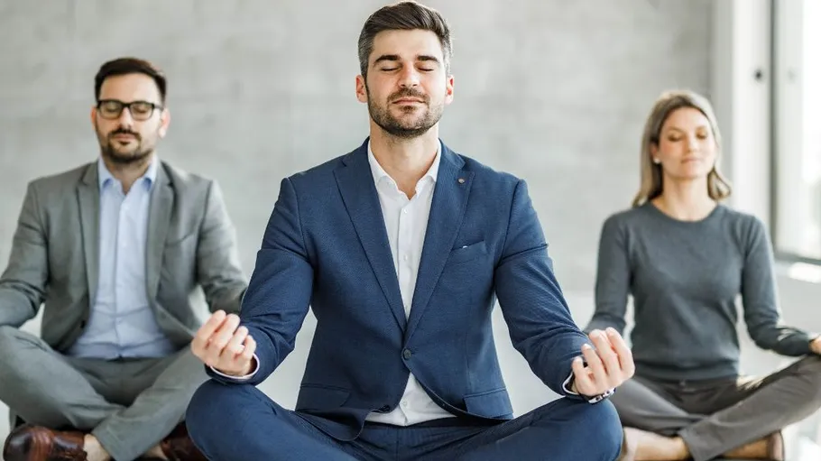 Three people meditating in an office.