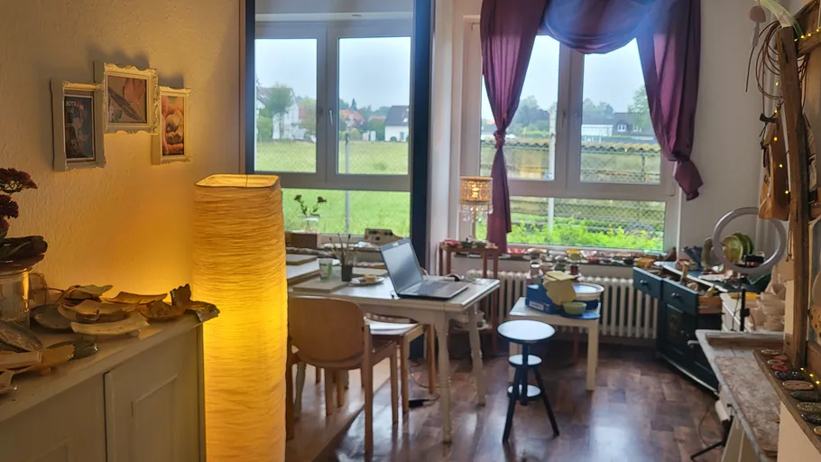 Gemütlicher Bastelraum mit Tisch und Dekorationen.