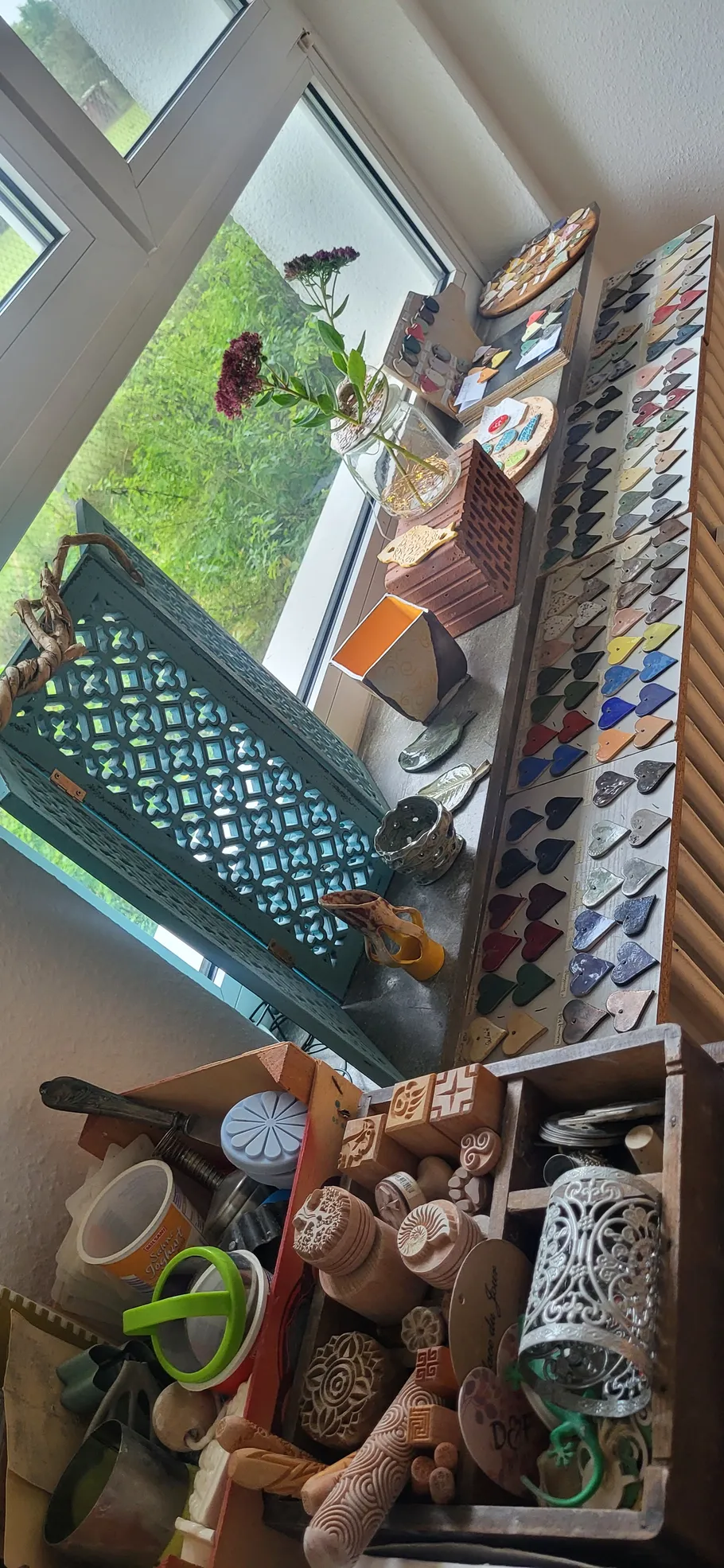 Bastelutensilien und Dekorationen auf Fensterbank.