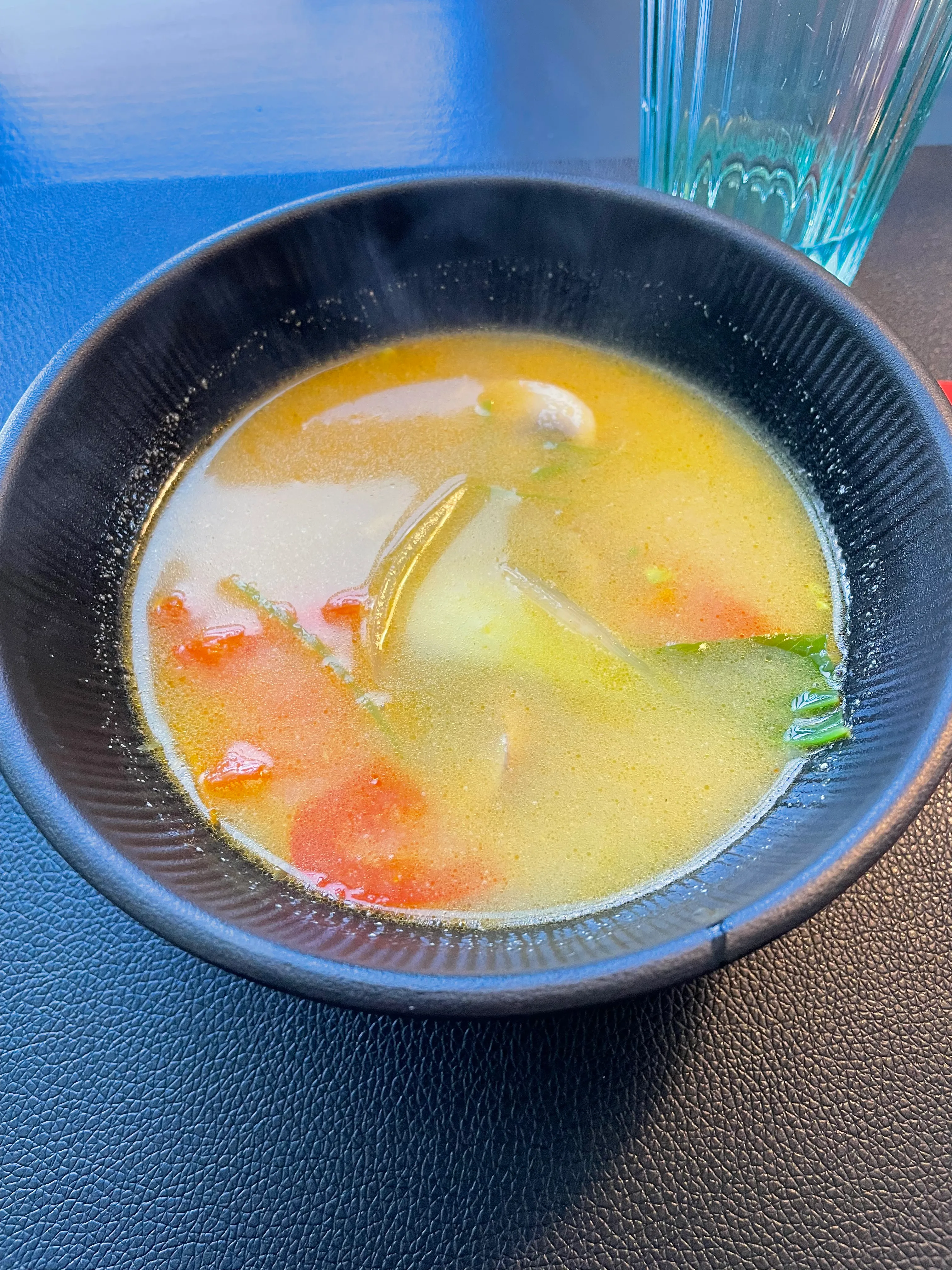 Schüssel Suppe mit Gemüse auf Tisch.