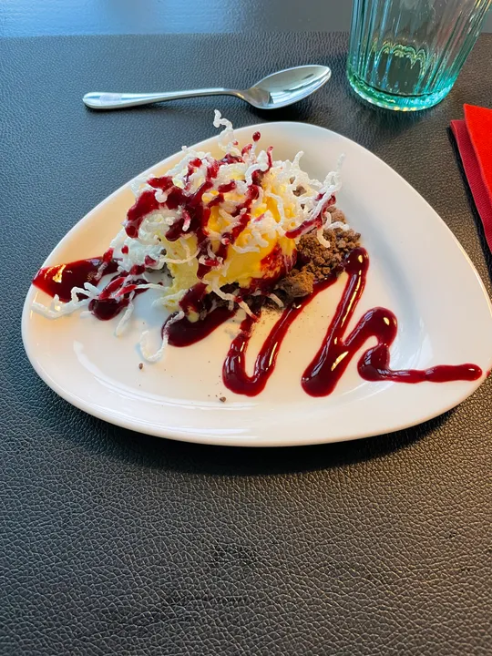 Dessert with sauce on triangular plate.