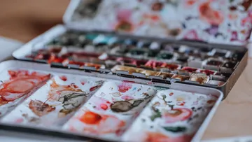Geöffnete Aquarellpalette mit verschiedenen Farben.