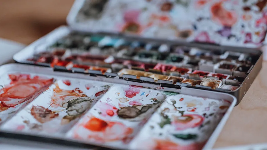 Open watercolor palette with various colors.