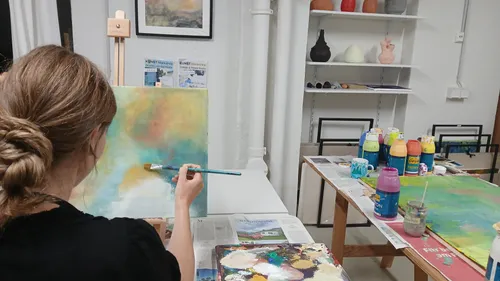 Frau malt auf Leinwand im Kunststudio.