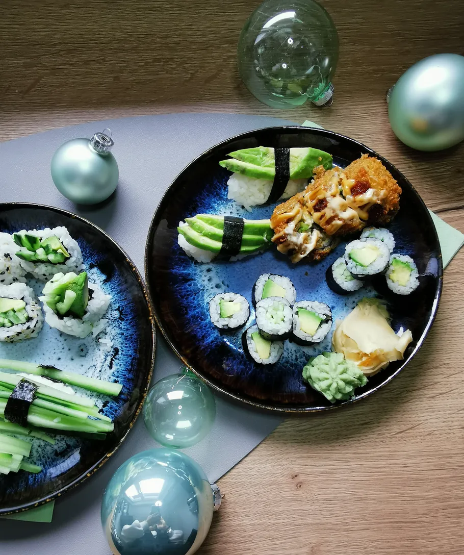 Sushi-Teller mit festlichen Ornamenten daneben.