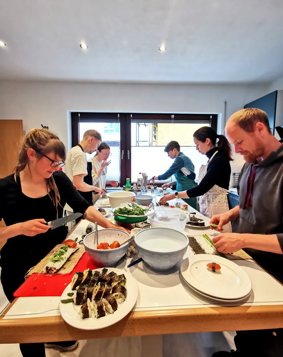 Gruppe macht Sushi in einer Küche.