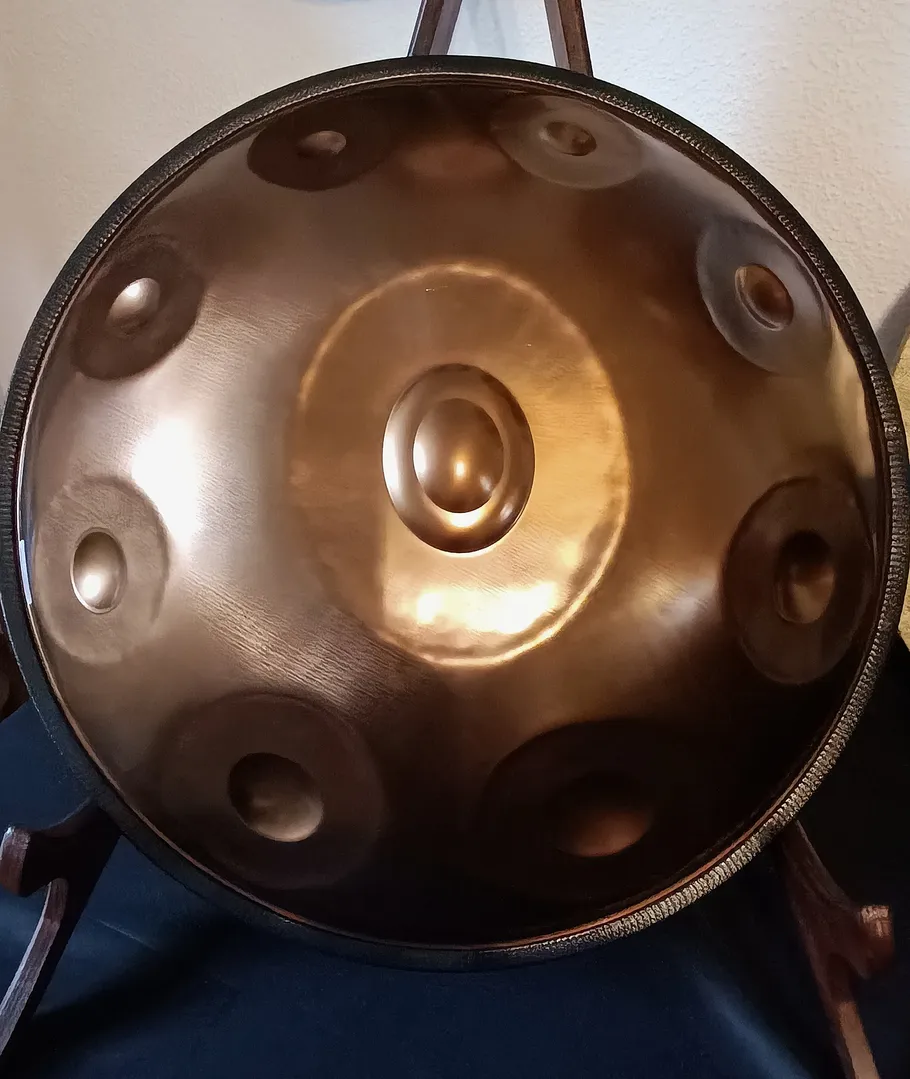 Handpan resting on a stand indoors.