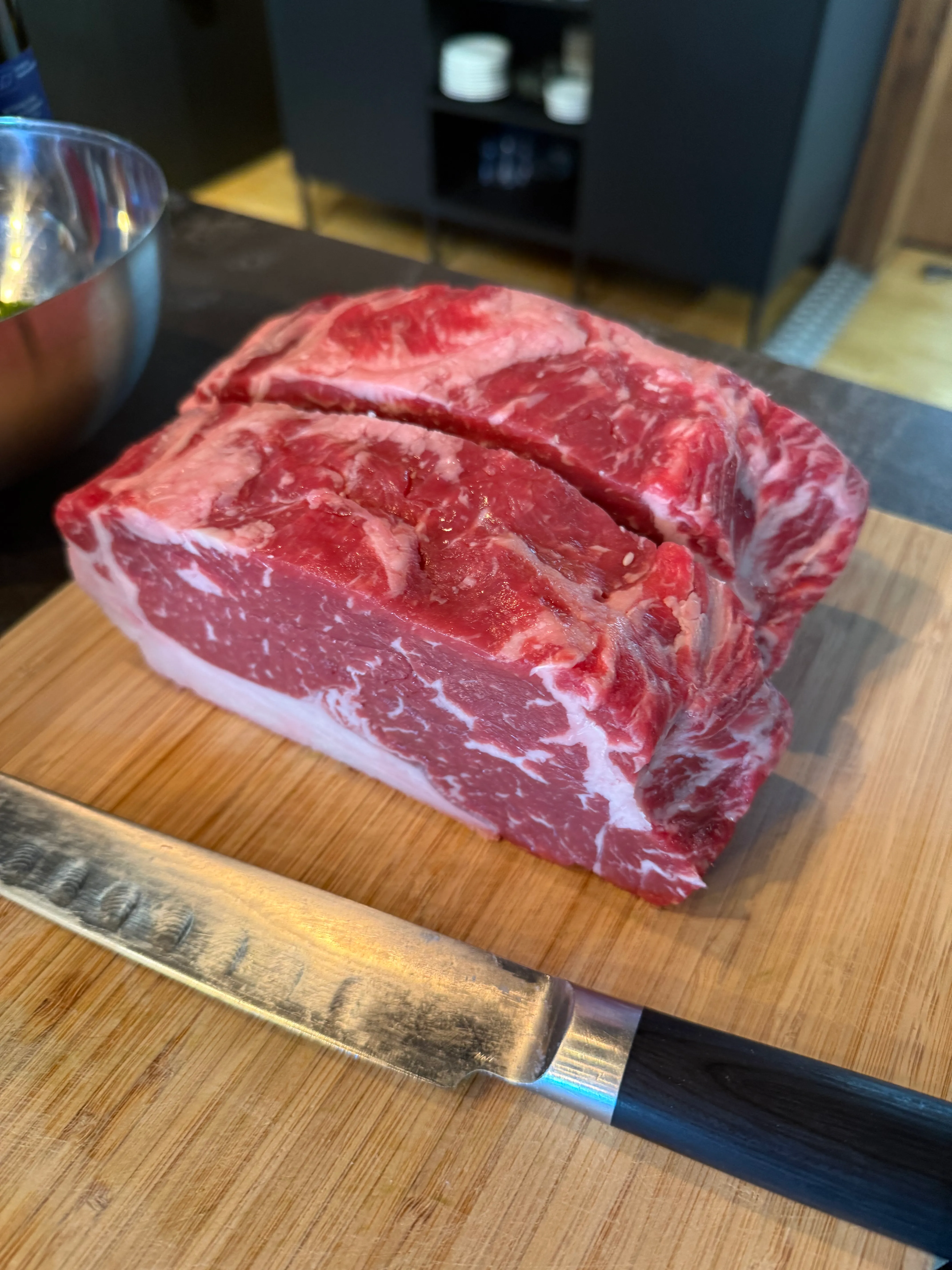 Rohes Rindfleisch mit Messer auf Schneidebrett.