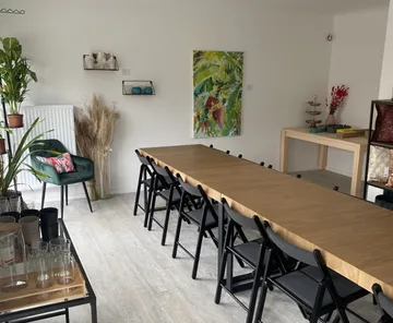 Langer Tisch mit Stühlen in dekoriertem Raum.