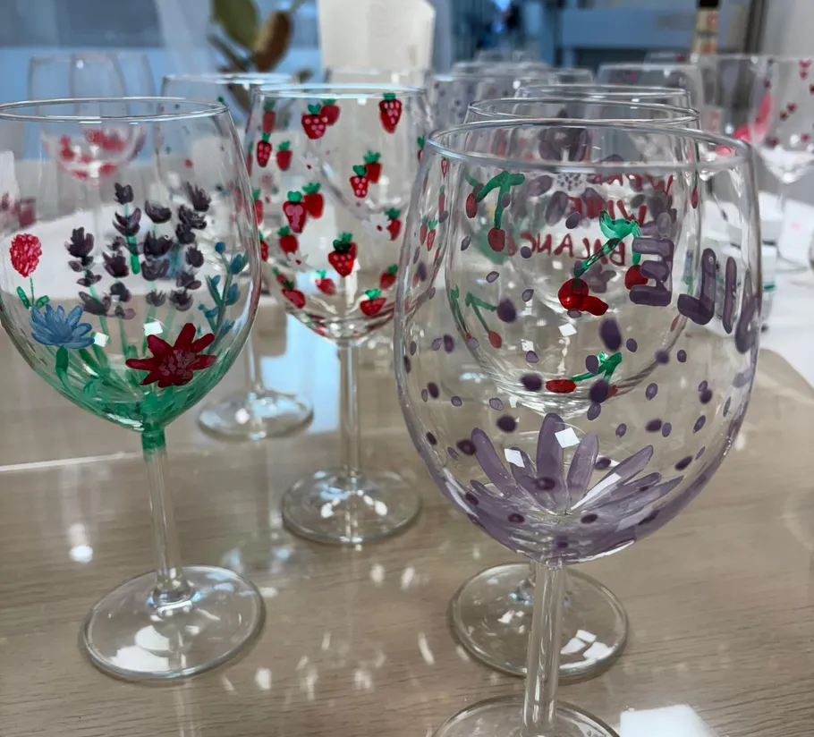 Dekorierte Weingläser mit Blumen- und Fruchtdesigns.