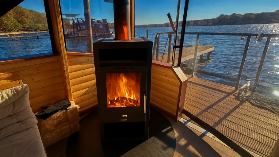 Wood stove burning inside lakeside cabin.