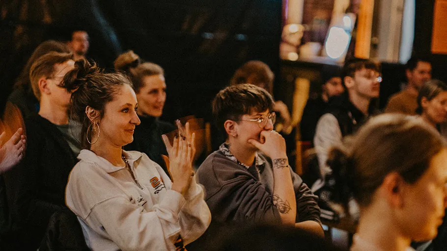 Audience attentively watching event indoors.