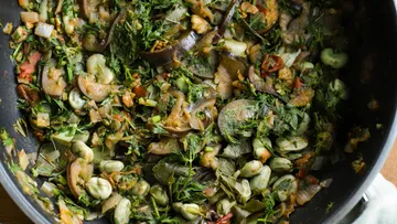 Vegetable stew in a black pan.