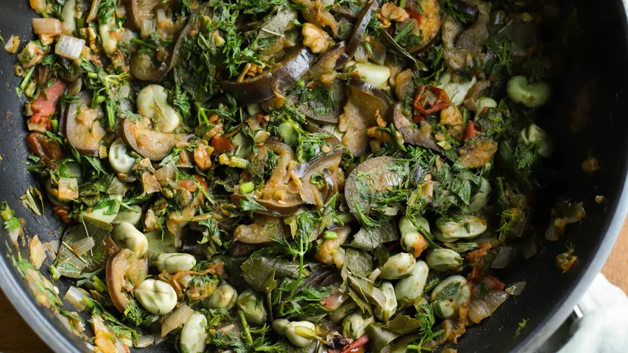 Vegetable stew in a black pan.