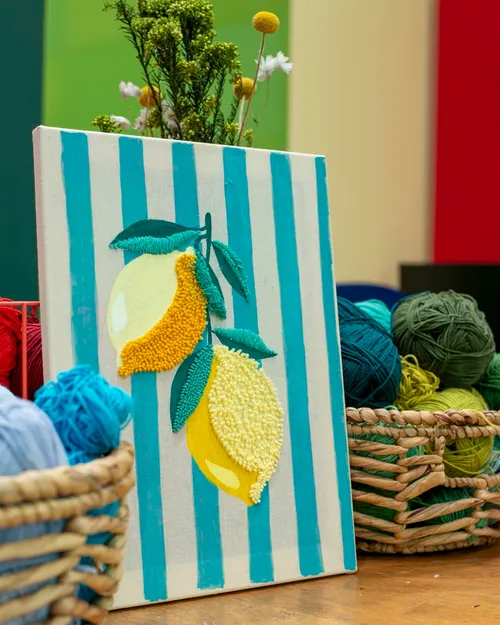 Embroidered lemons on canvas with yarn baskets.