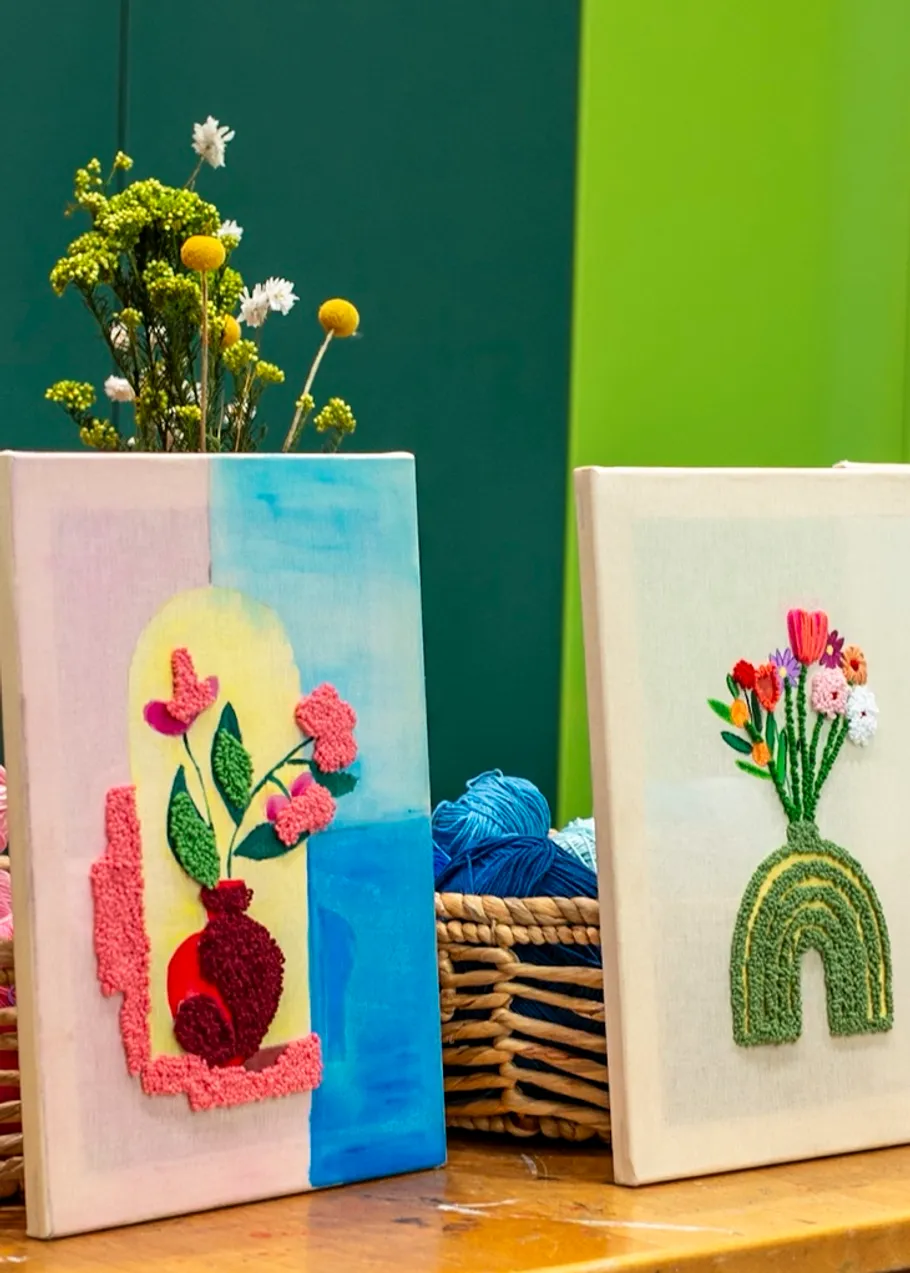 Zwei bestickte Leinwände mit Blumendesigns ausgestellt.