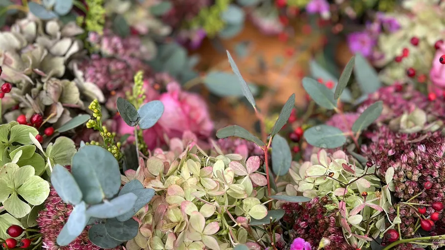Bunte Blumen und Blätter zusammen arrangiert.