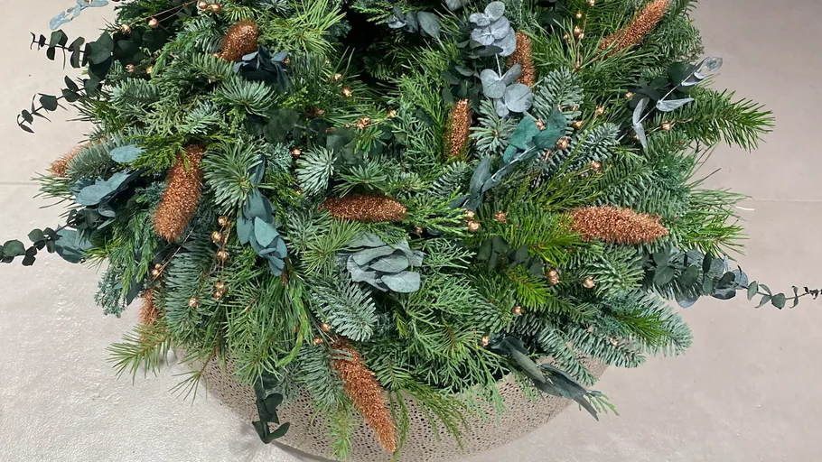 Grüner Kranz auf hellem Bodenbelag.