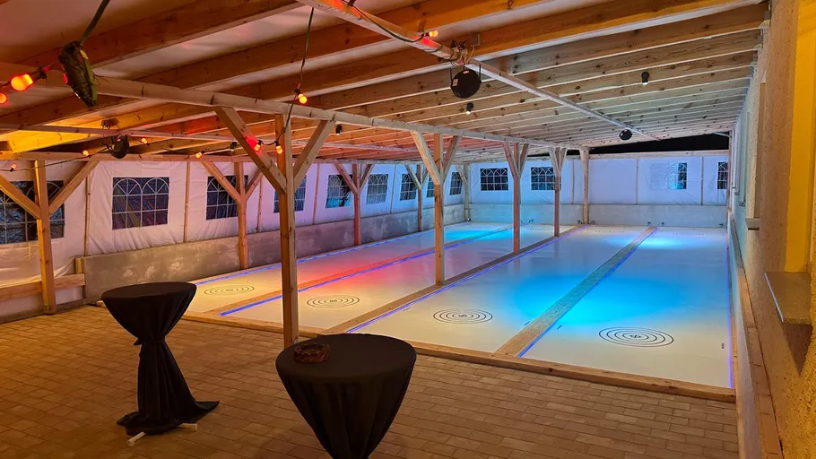 Indoor-Curlingbahn mit bunter Beleuchtung.