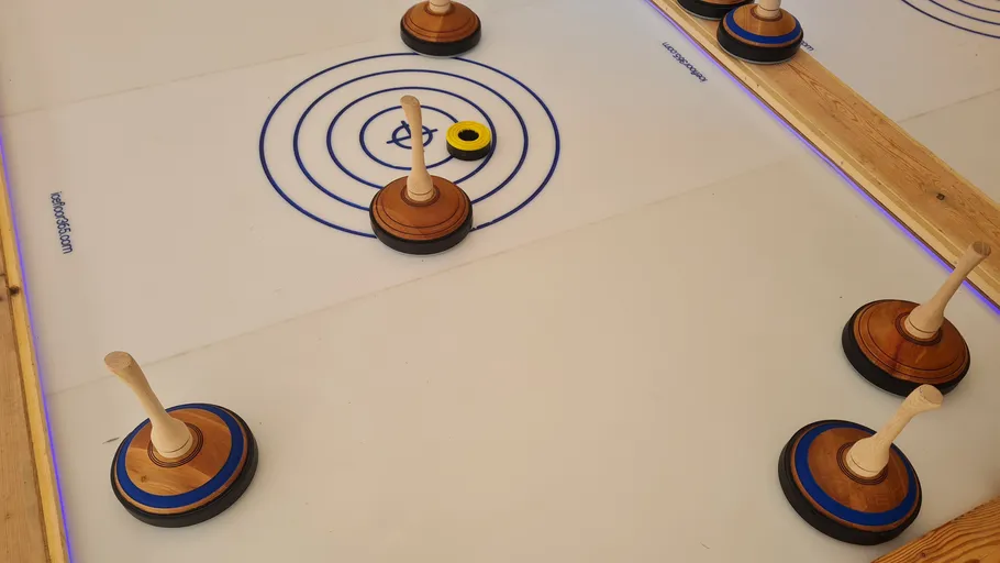 Curling stones on indoor ice rink table.