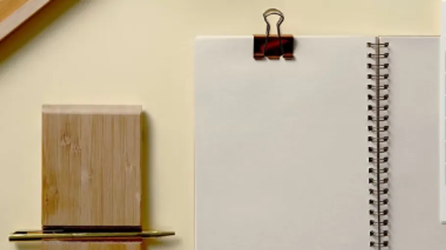 Open notebook with binder clip on desk.