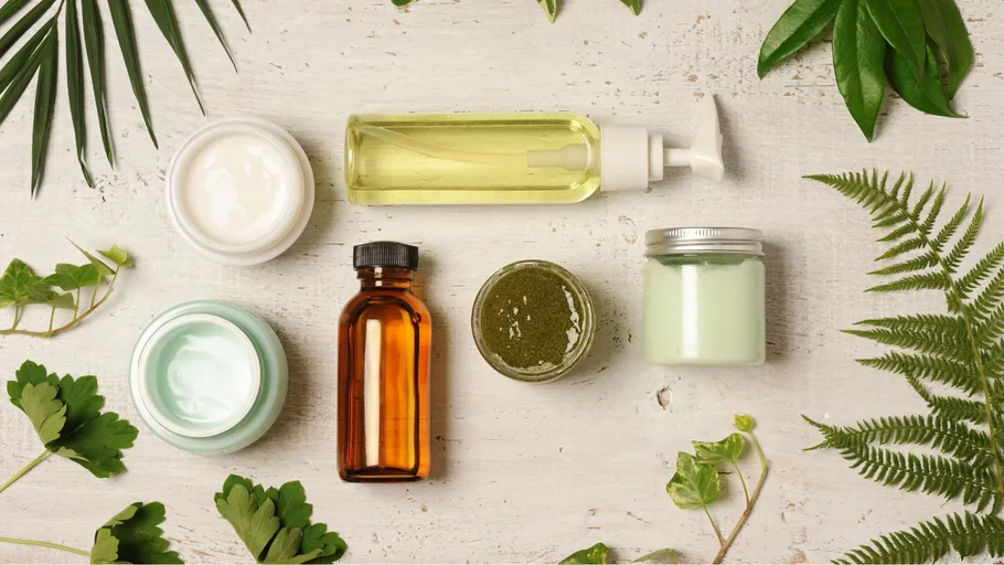 Skin care products surrounded by green leaves.