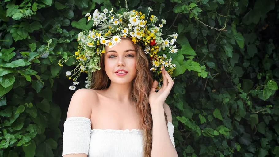 Frau mit Blumenkron, blättrigem Hintergrund.