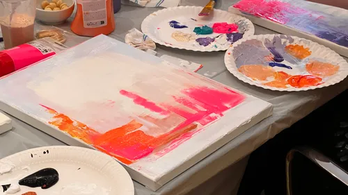 Abstract painting with paint palettes on table.