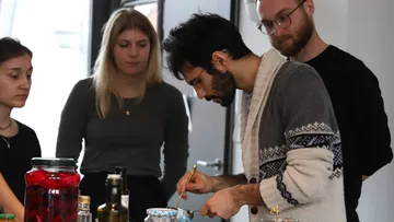 Four people cooking in a kitchen.