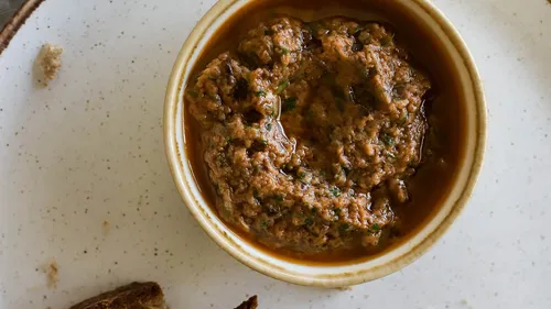 Brown dip in a white bowl on plate.