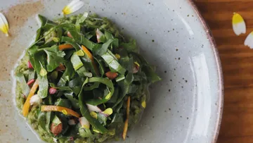 Green salad on speckled ceramic plate.
