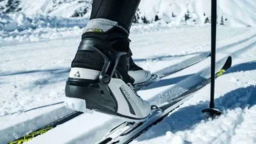 Skischuhe auf schneebedecktem Bergpfad.