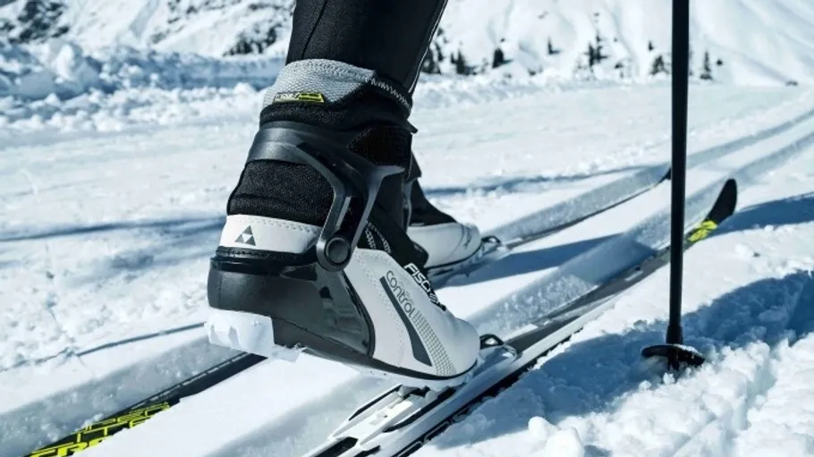 Skischuhe auf schneebedecktem Bergpfad.