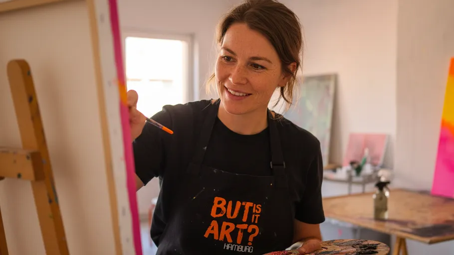 Woman painting on canvas in art studio.