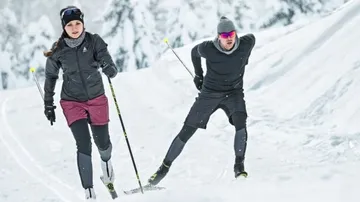 Two cross-country skiers in snowy landscape.