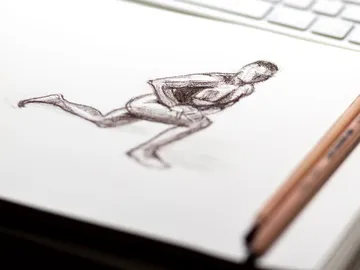 Quick drawing of a running human body on paper.