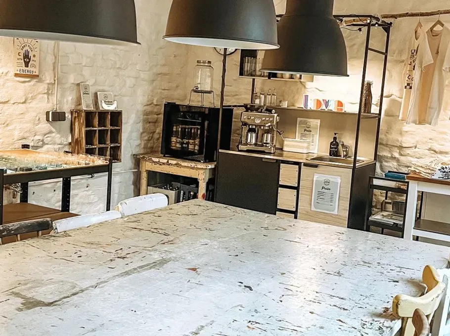 Rustic kitchen with coffee machine and tables.