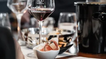 Wine glass and appetizer on table.