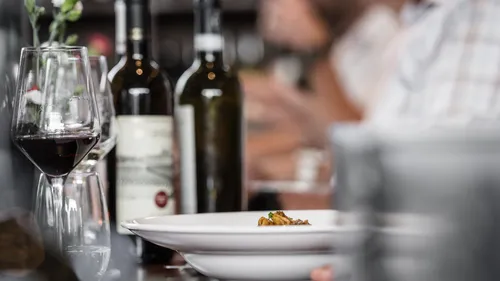 Wine glasses and bottles on restaurant table.