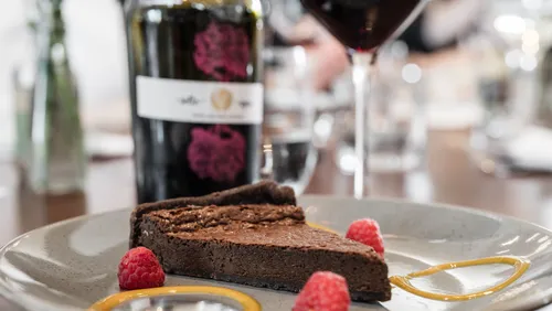 Schokoladenkuchen und Wein auf Restauranttisch.