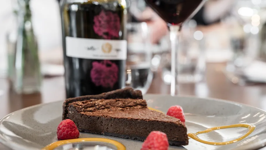 Schokoladenkuchen und Wein auf Restauranttisch.