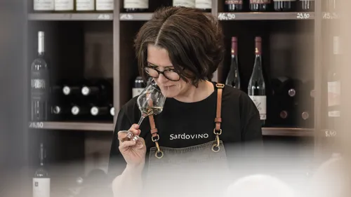 Frau riecht Wein in einem Weinladen.