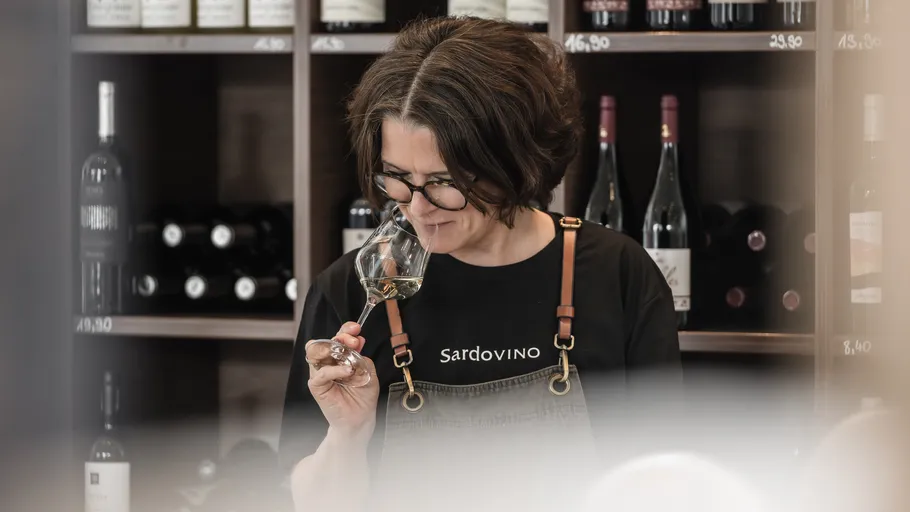 Frau riecht Wein in einem Weinladen.