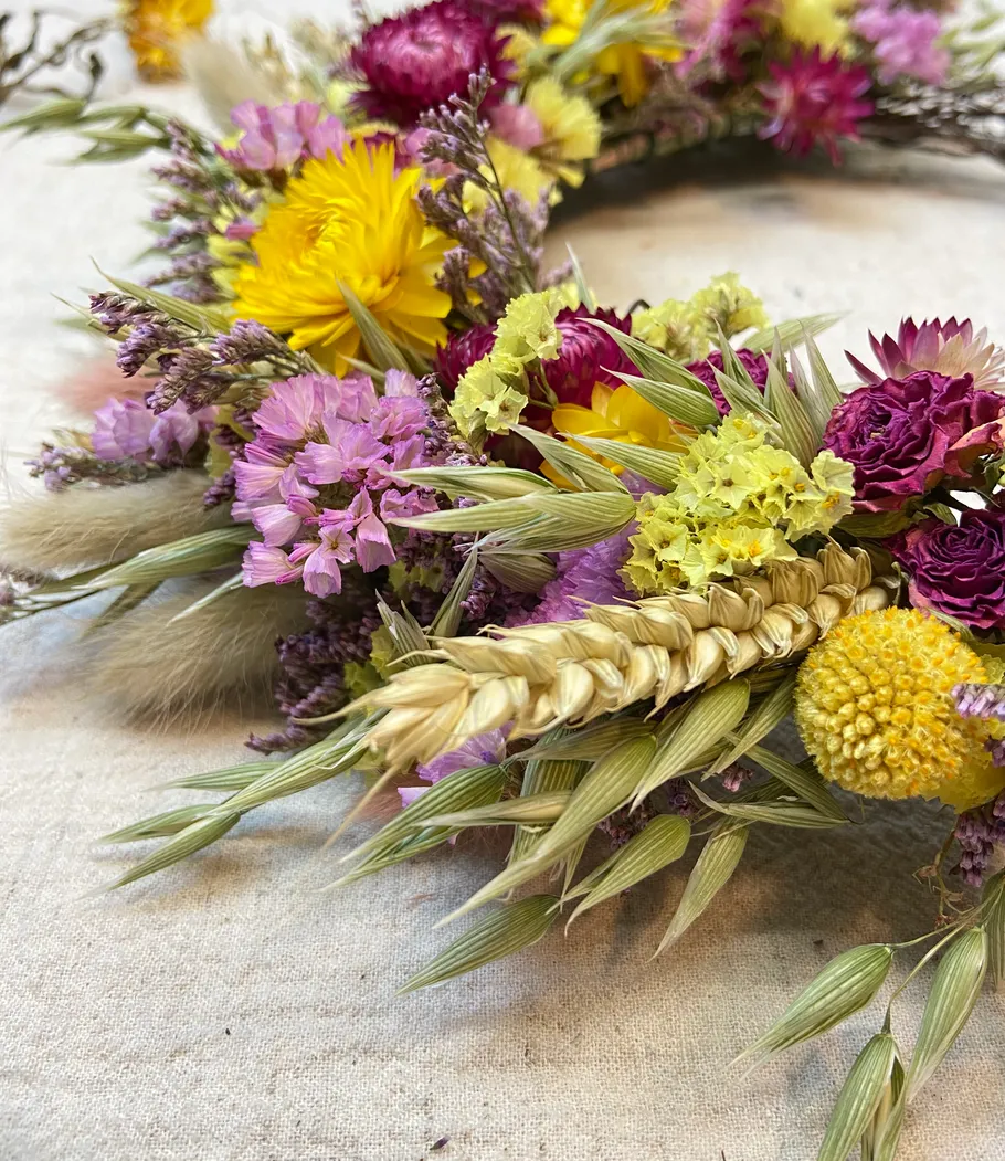 Bunter Trockenblumenkranz auf Tisch.
